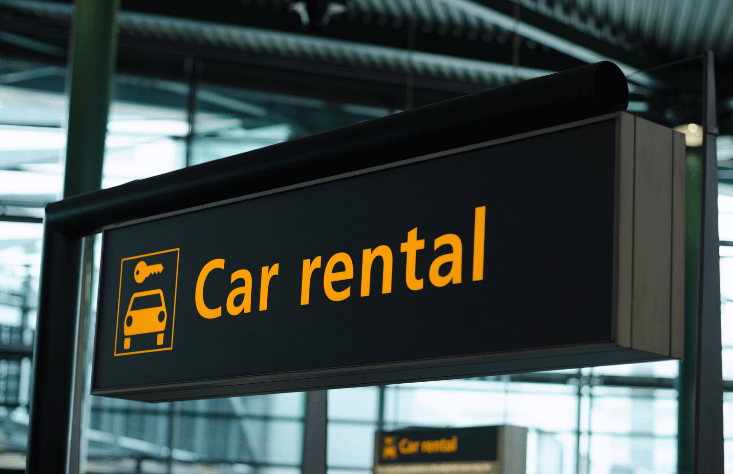 Airport sign for a car rental area, representing the importance of understanding rental car insurance options in Newfoundland and Labrador.