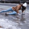 A person slipping on an icy sidewalk during winter, illustrating the risk of slip and fall liability claims for Newfoundland homeowners.