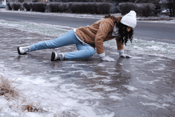 A person slipping on an icy sidewalk during winter, illustrating the risk of slip and fall liability claims for Newfoundland homeowners.