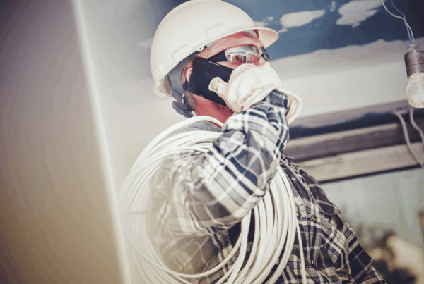 Electrical contractor wearing safety gear on a job site, highlighting common insurance gaps like tools in transit, subcontractor liability, and completed operations coverage.