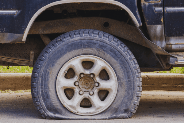 Flat tire on a truck after hitting a pothole, showing how road damage can cause tire failure and vehicle damage for drivers.