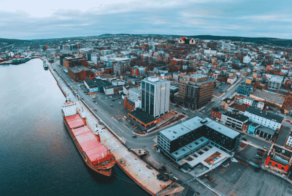 Aerial view of downtown St. John’s, Newfoundland and Labrador waterfront with commercial buildings and cargo ship, highlighting the importance of proper insurance coverage for local businesses.