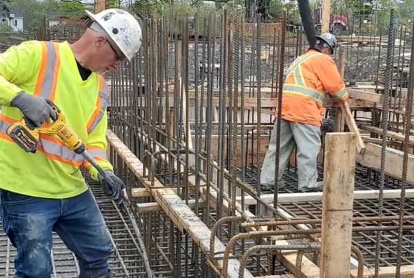Screengrab of workers pouring concrete and working with rebar in a client spotlight video for KelCo Construction