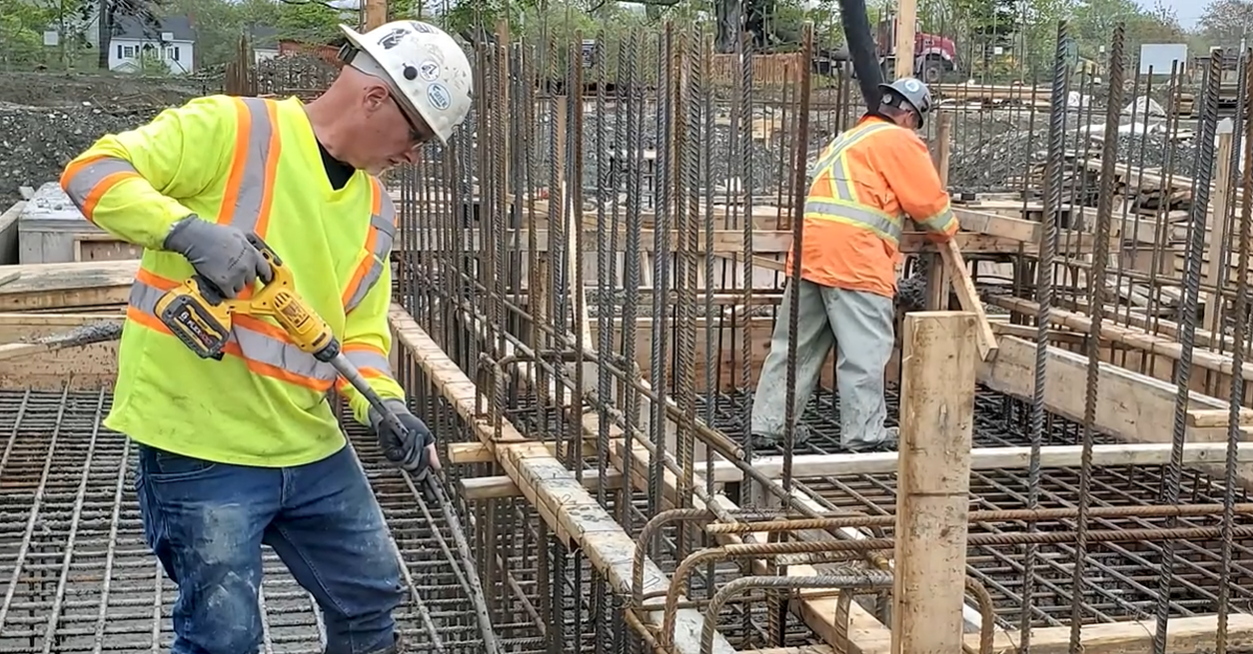 Screengrab of workers pouring concrete and working with rebar in a client spotlight video for KelCo Construction