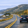 Car travelling along a coastal highway in Newfoundland and Labrador in fall driving conditions.