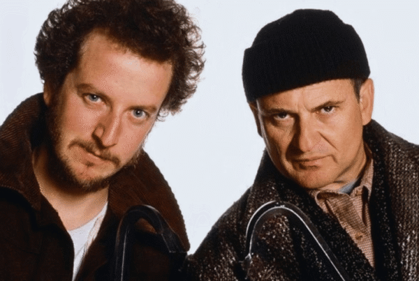 Two individuals dressed in winter clothing holding tools, used to illustrate the importance of securing your home before leaving for vacation.
