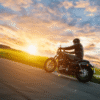 Motorcycle rider on an open road at sunset, representing spring riding season in Newfoundland