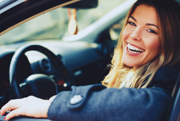 Driver seated in a parked car with the window open, illustrating peace of mind and confidence when choosing or switching car insurance.